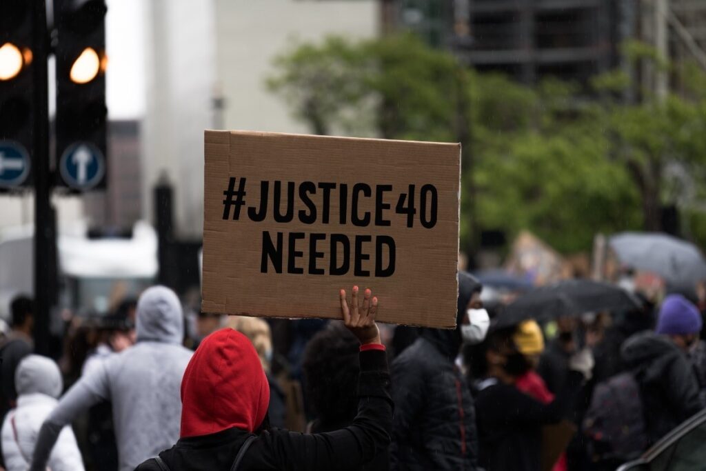 Protest with a sign that says "#Justice40 Needed"