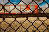 Looking at train cars through a chain-link fence
